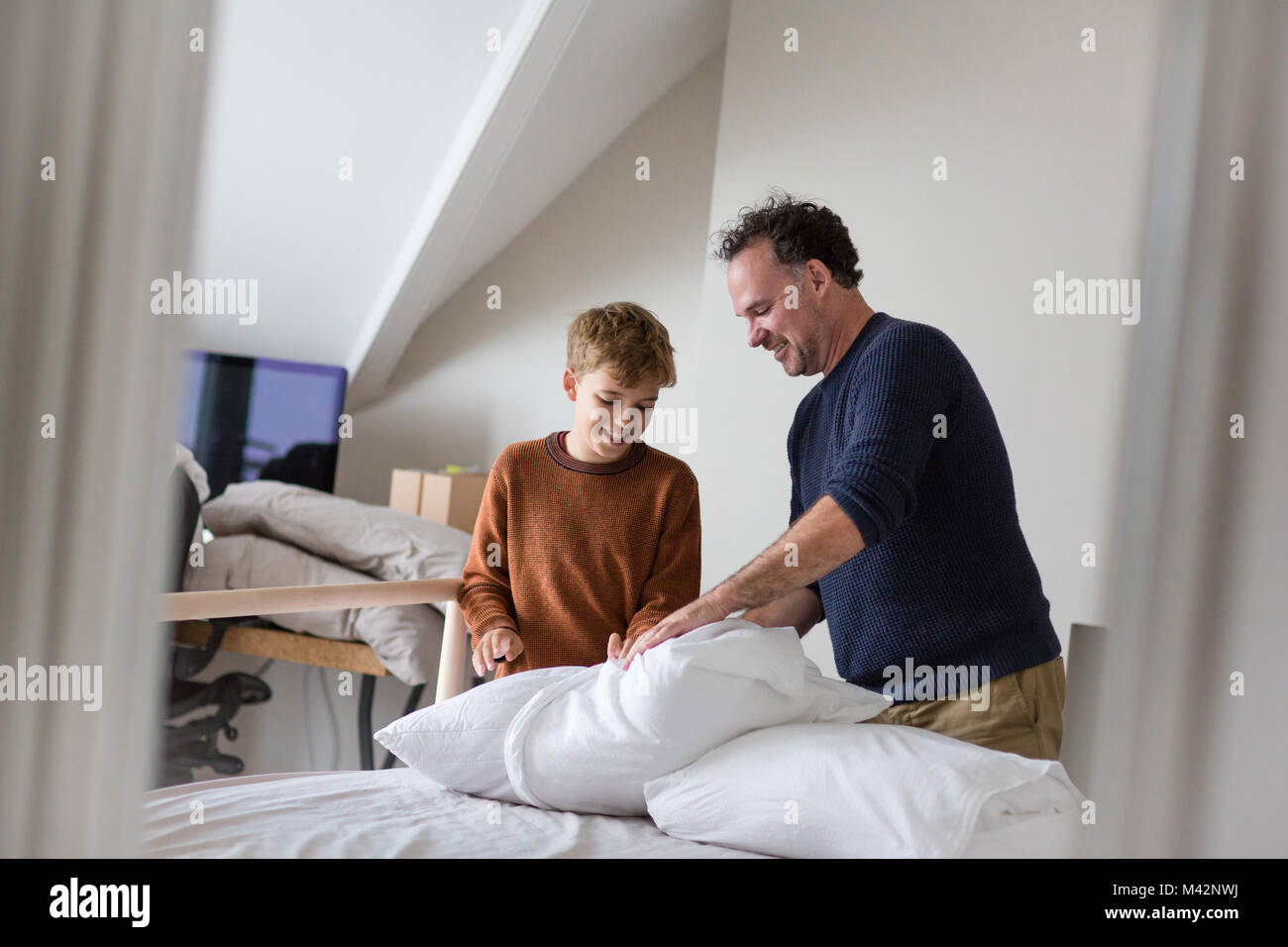 Padre figlio di insegnamento come fare il letto Foto Stock