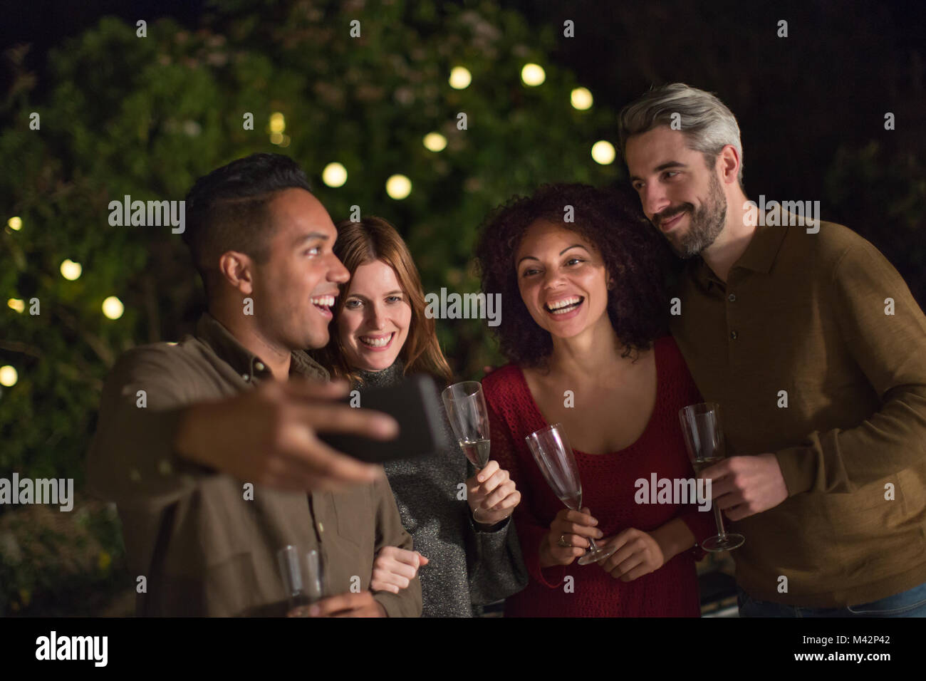 Amici celebrando all'aperto prendendo un selfie Foto Stock