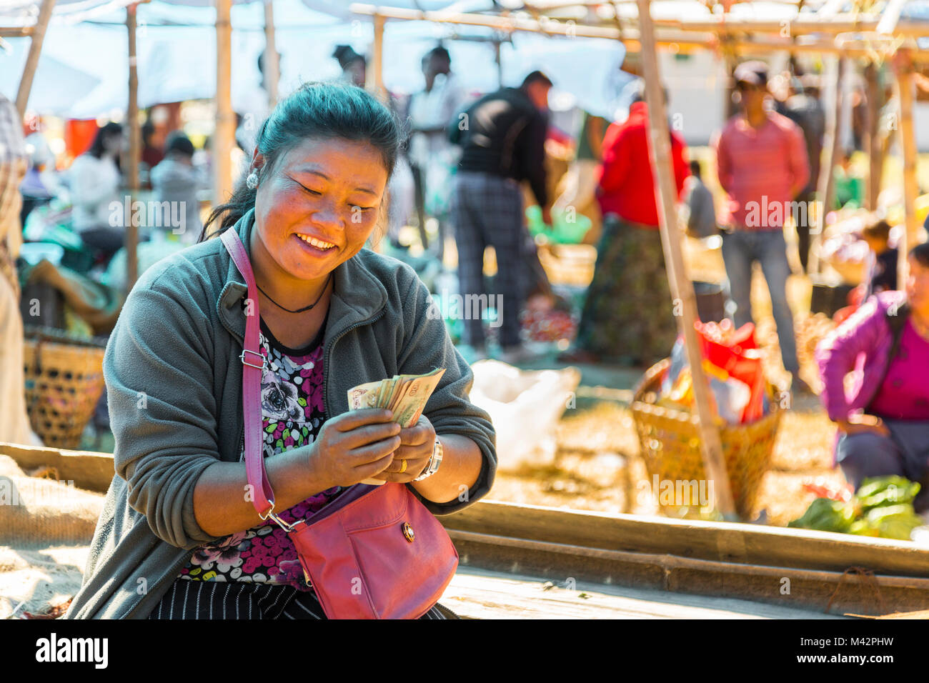 Punakha, Bhutan. La donna a contare i suoi soldi nel mercato di frutta e verdura. Foto Stock