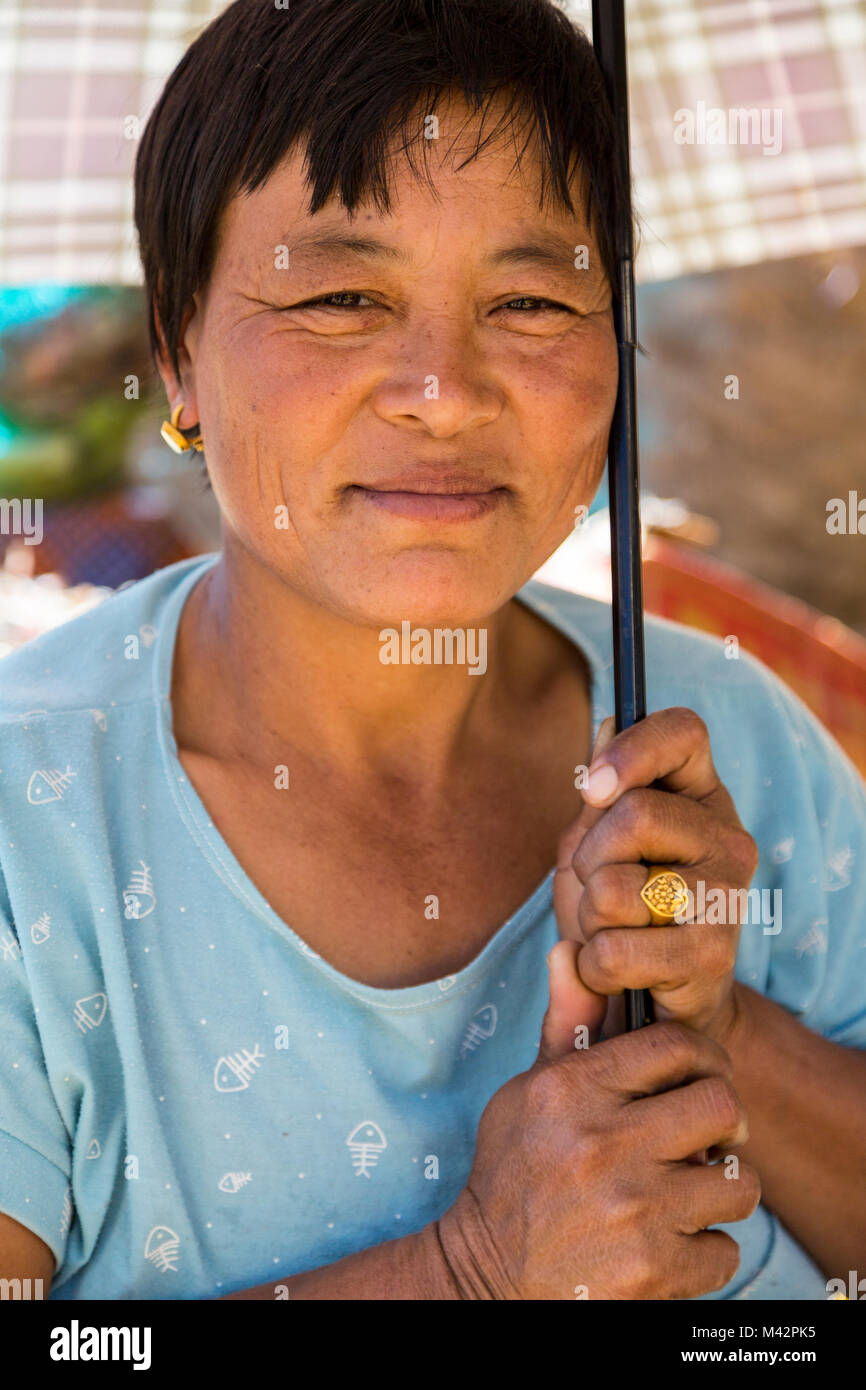 Punakha, Bhutan. Mercato di frutta e verdura, Donna con ombrello. Foto Stock