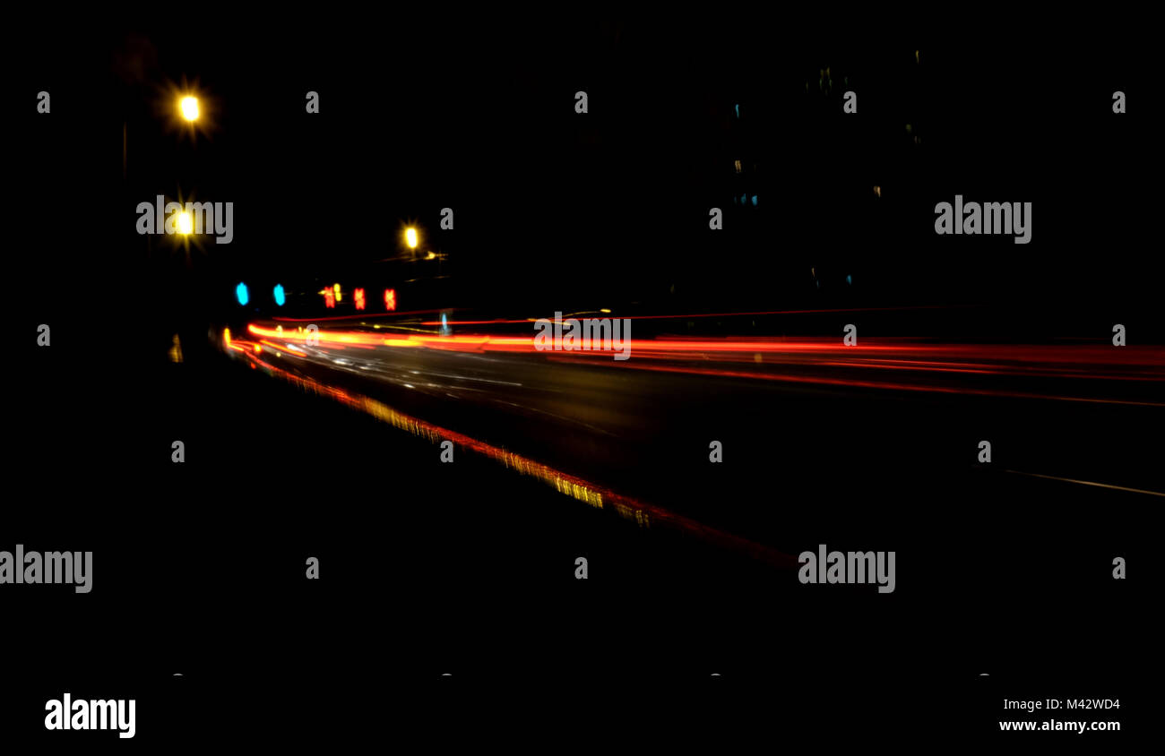 Sfocata Illuminazione e luci notturne, il traffico automobilistico motion blur la velocità e dinamica Foto Stock