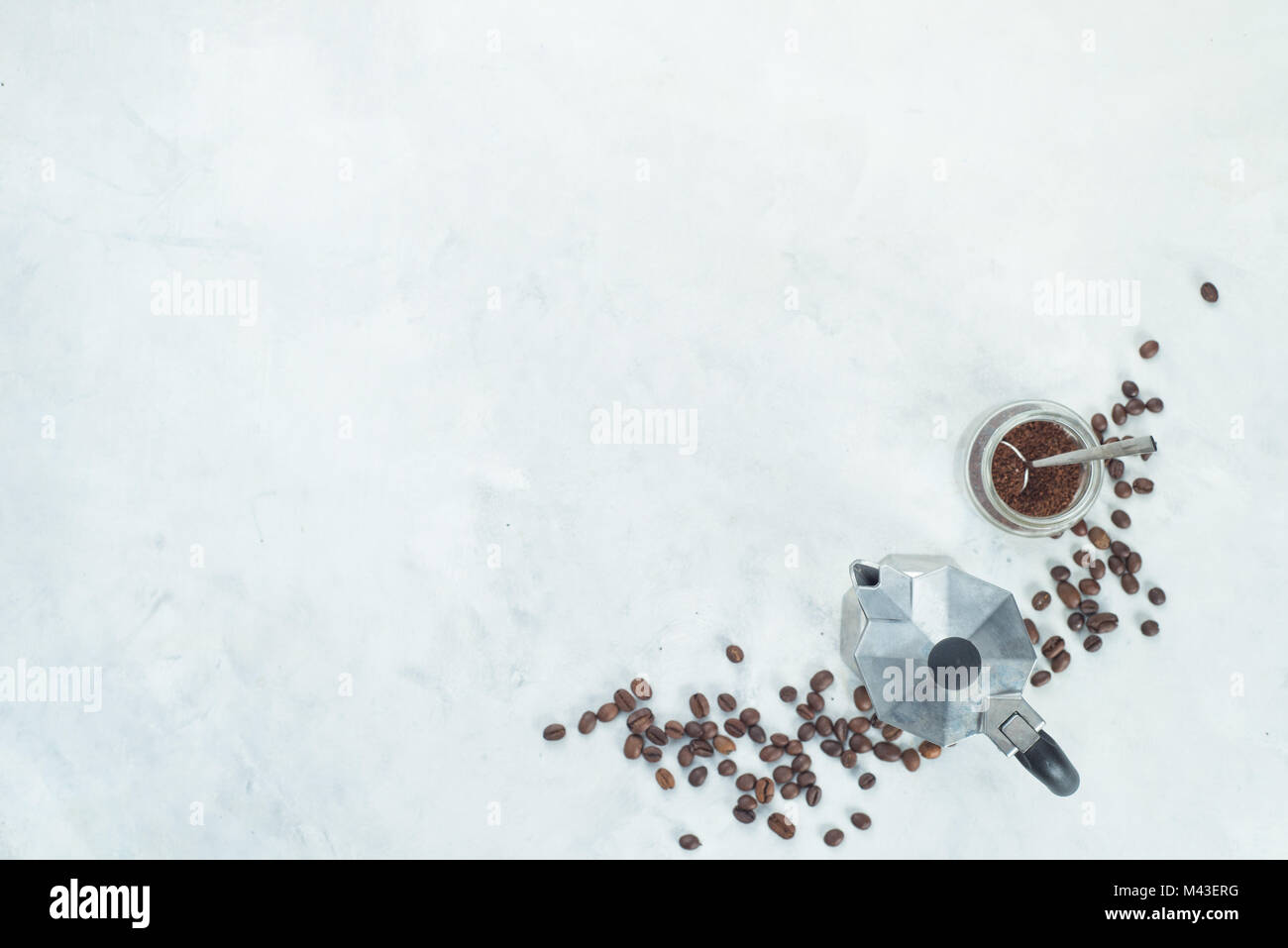 Geyser caffettiera con fagioli e caffè macinato in un vasetto di vetro. Elevato La chiave bere la fotografia dal di sopra. Foto Stock