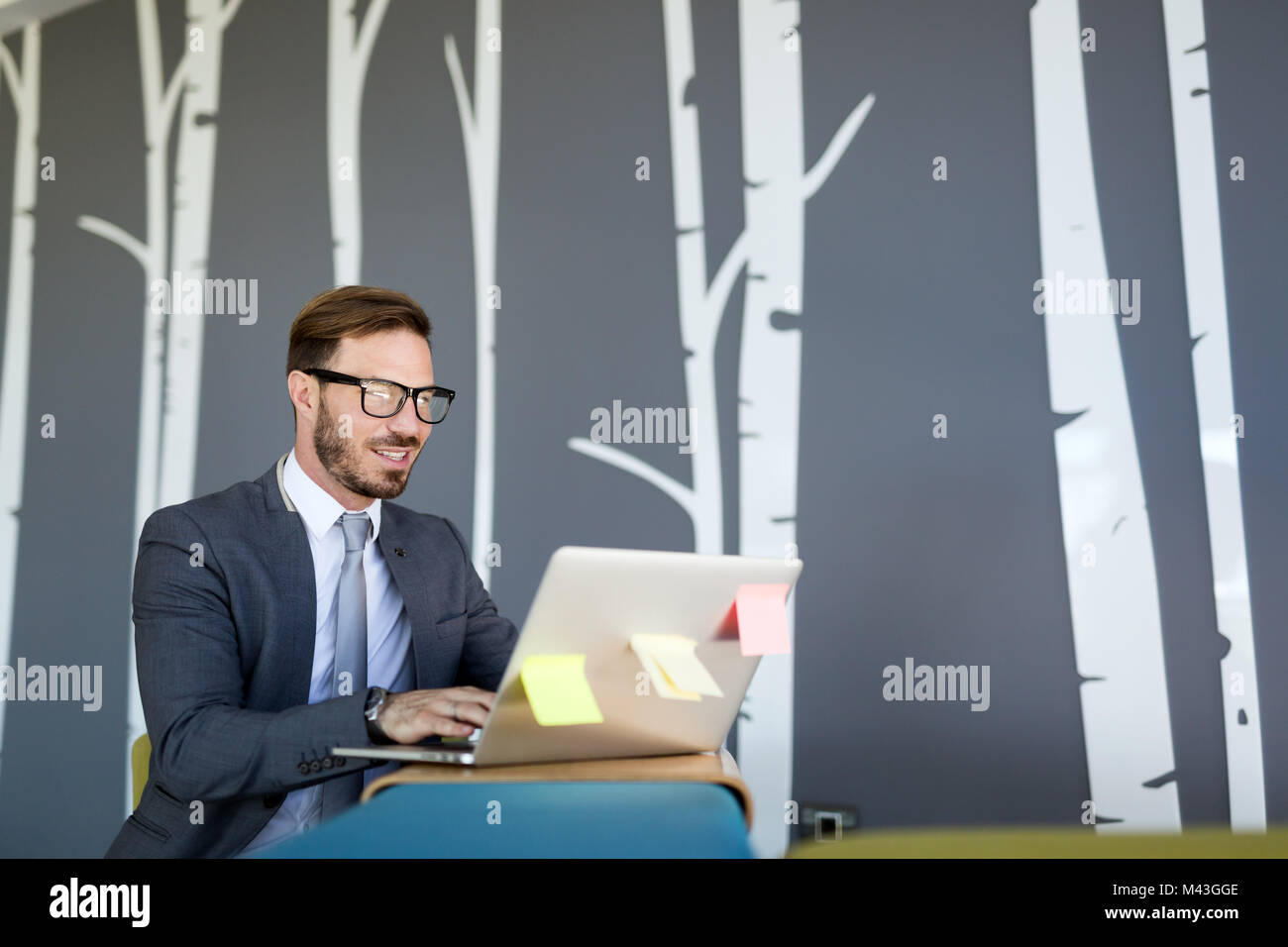 Imprenditore bello lavorare sul computer portatile in ufficio Foto Stock