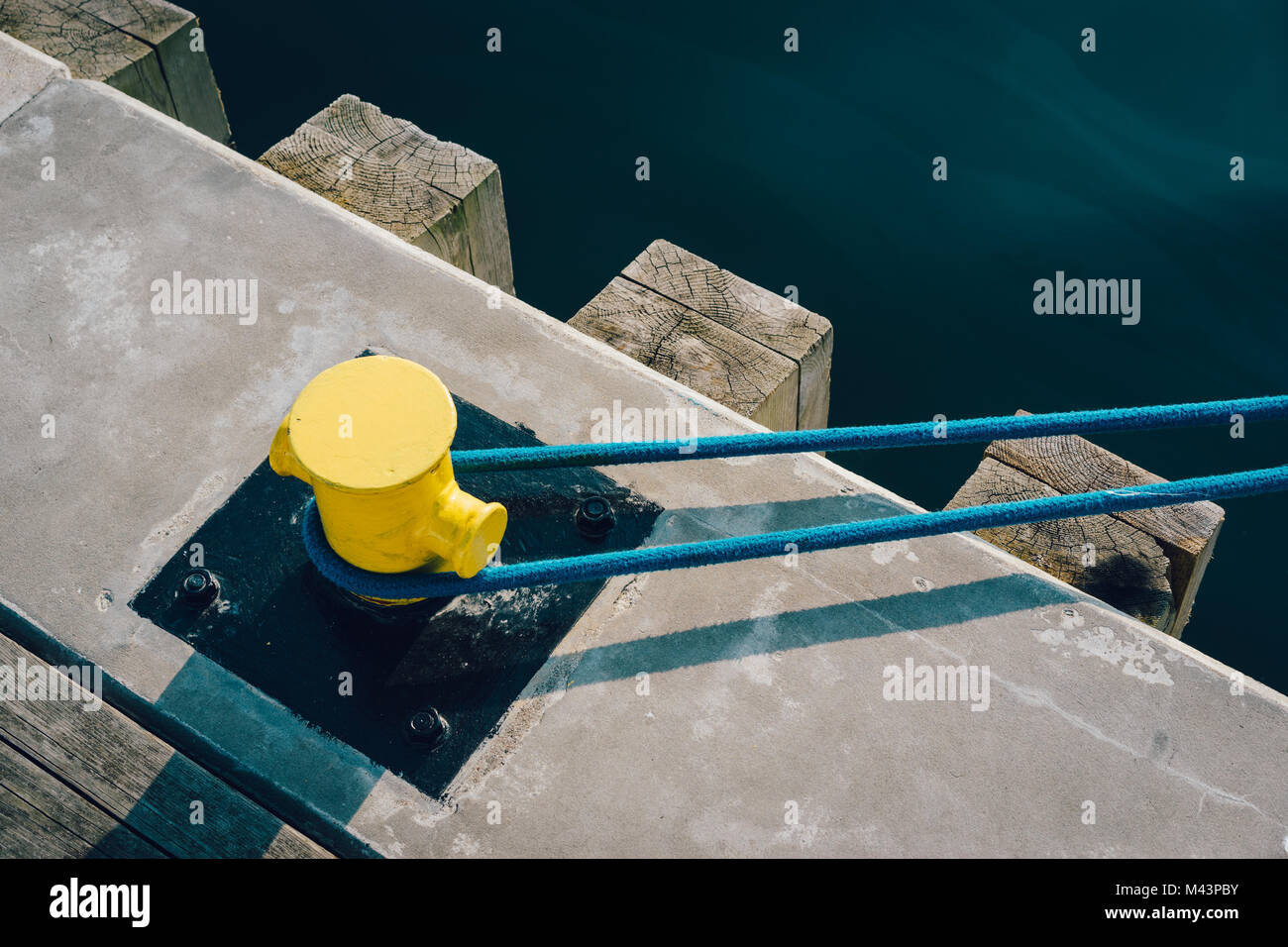 Giallo bollard ormeggio sul molo con la cima di ormeggio Foto Stock