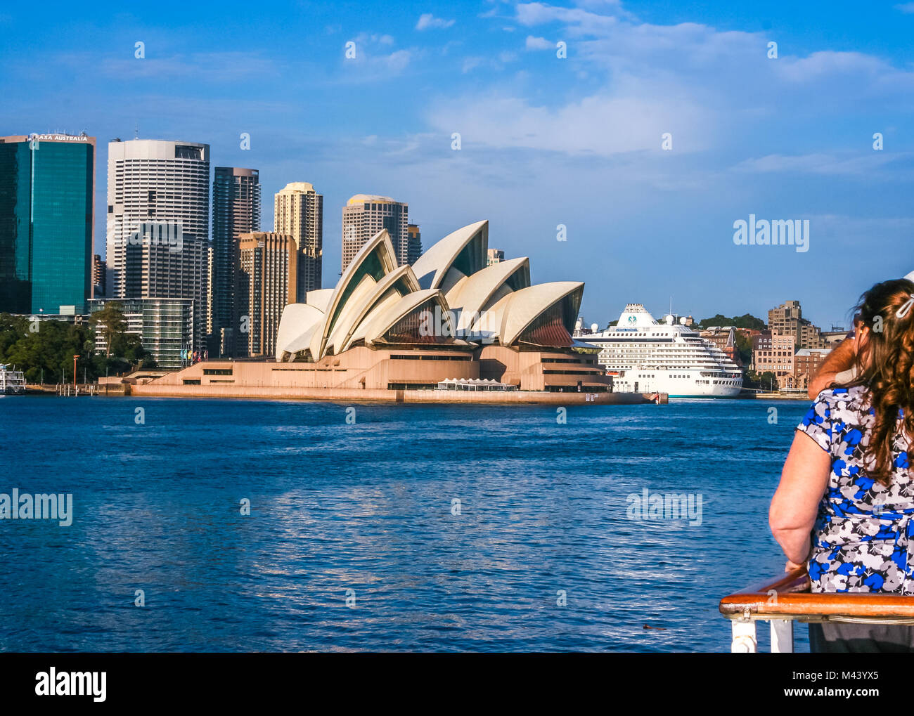 Gruppo di turisti che si godono di una bellissima vista di Sydney, Australia, skyline dalla barca in un giorno chiaro; famosa Opera House di Sydney nel centro Foto Stock