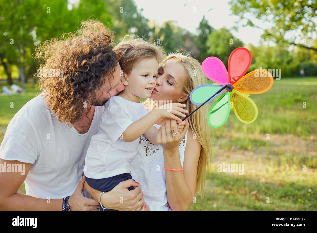 La famiglia felice che giocano nel parco. Foto Stock