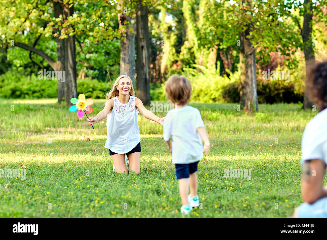 La famiglia felice che giocano nel parco. Foto Stock