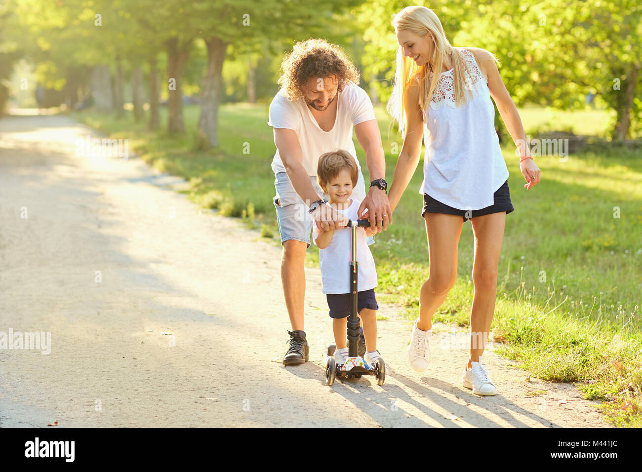 La famiglia felice che giocano nel parco. Foto Stock