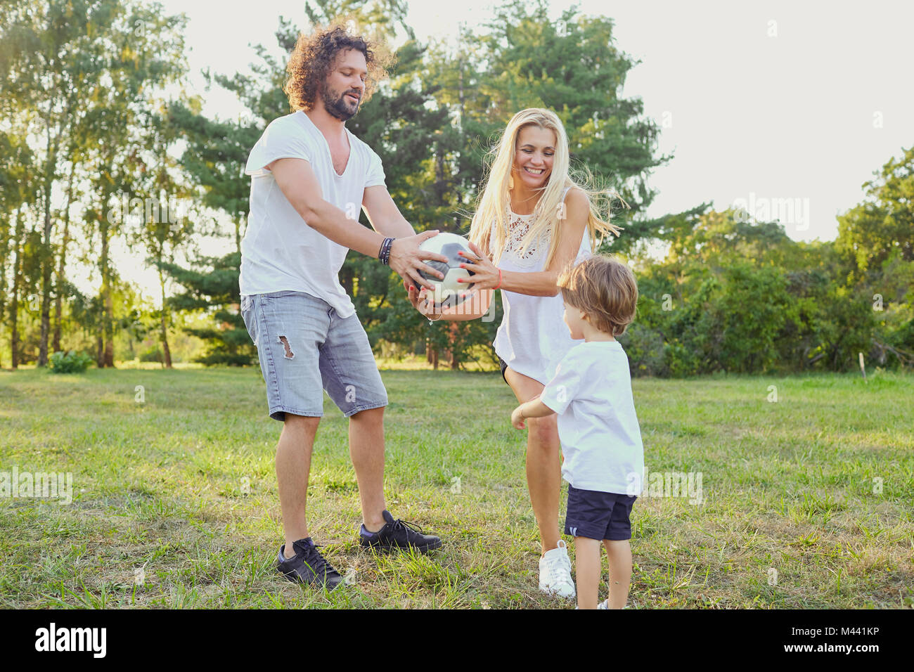 La famiglia gioca con una palla nel parco. Foto Stock