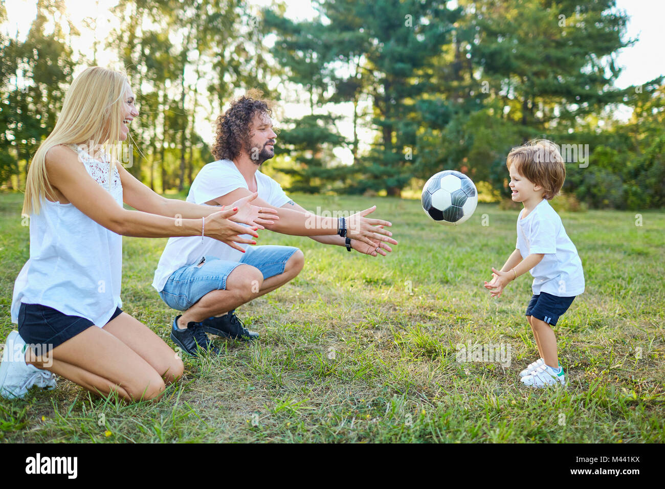 La famiglia gioca con una palla nel parco. Foto Stock