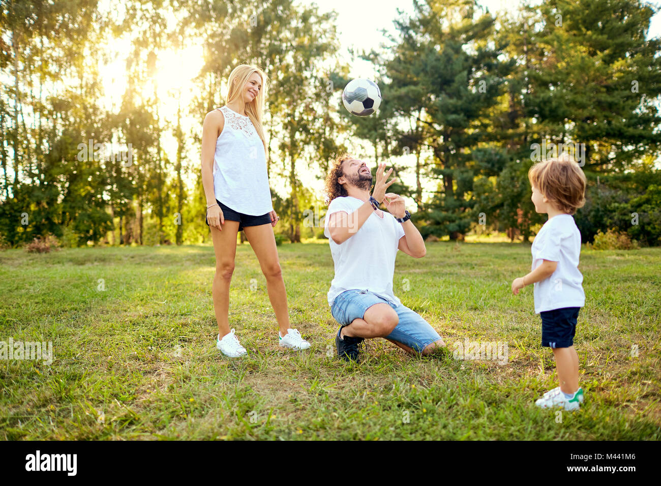 La famiglia gioca con una palla nel parco. Foto Stock