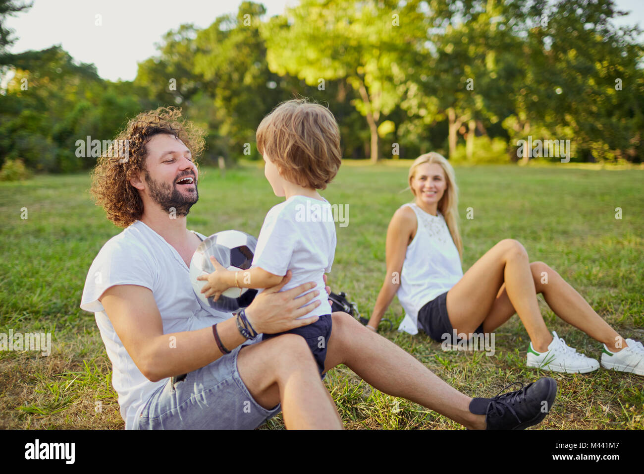 La famiglia gioca con una palla nel parco. Foto Stock