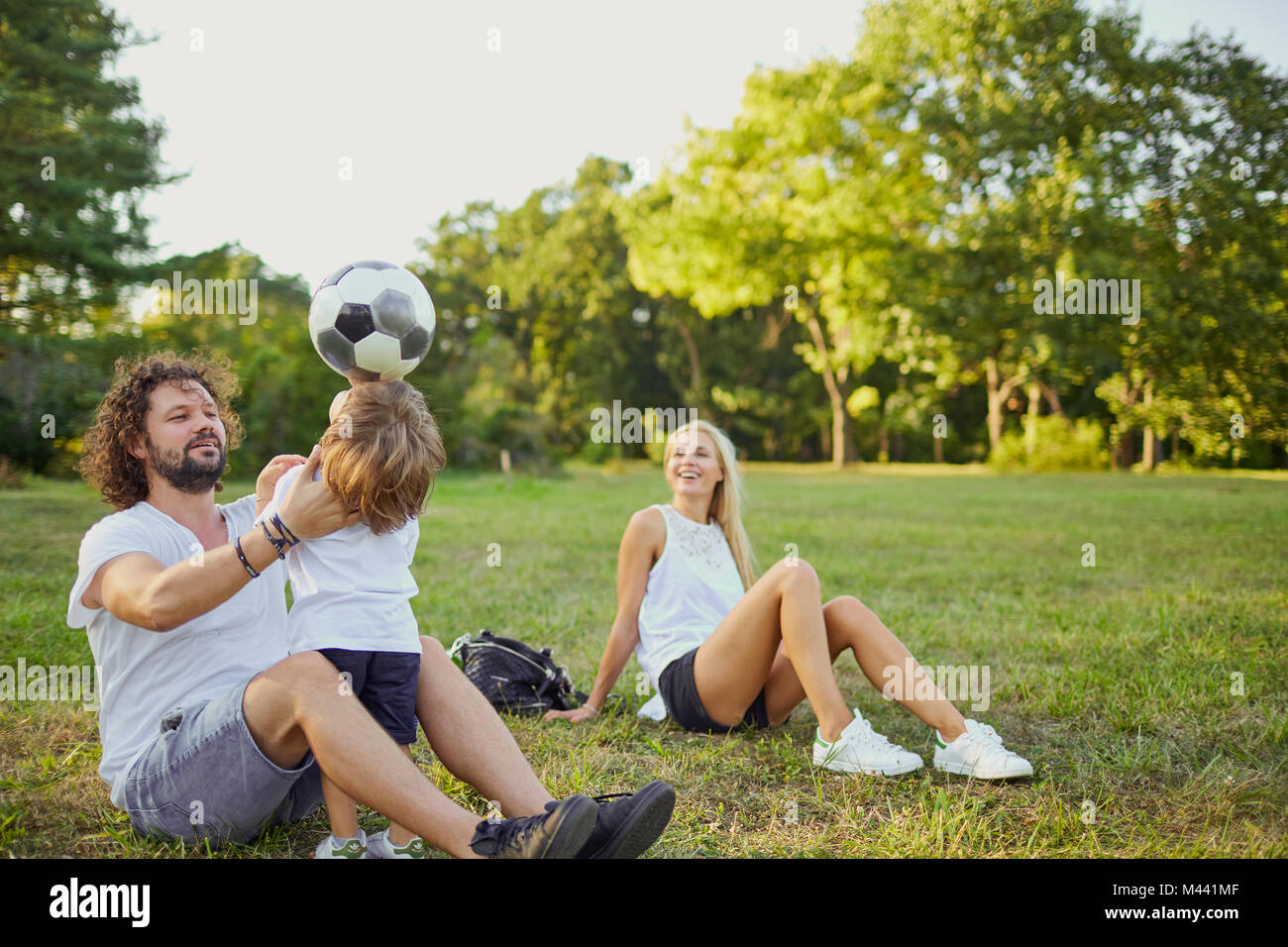 La famiglia gioca con una palla nel parco. Foto Stock