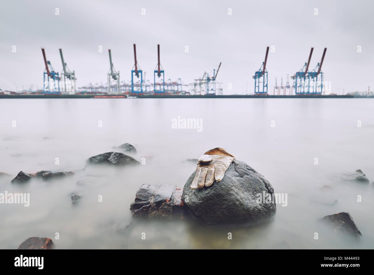 Perso il guanto sulla pietra nel porto. Fiume Elba in Amburgo, Germania. I temi del duro lavoro, l'ambiente, l'industria o di disoccupazione. Foto Stock