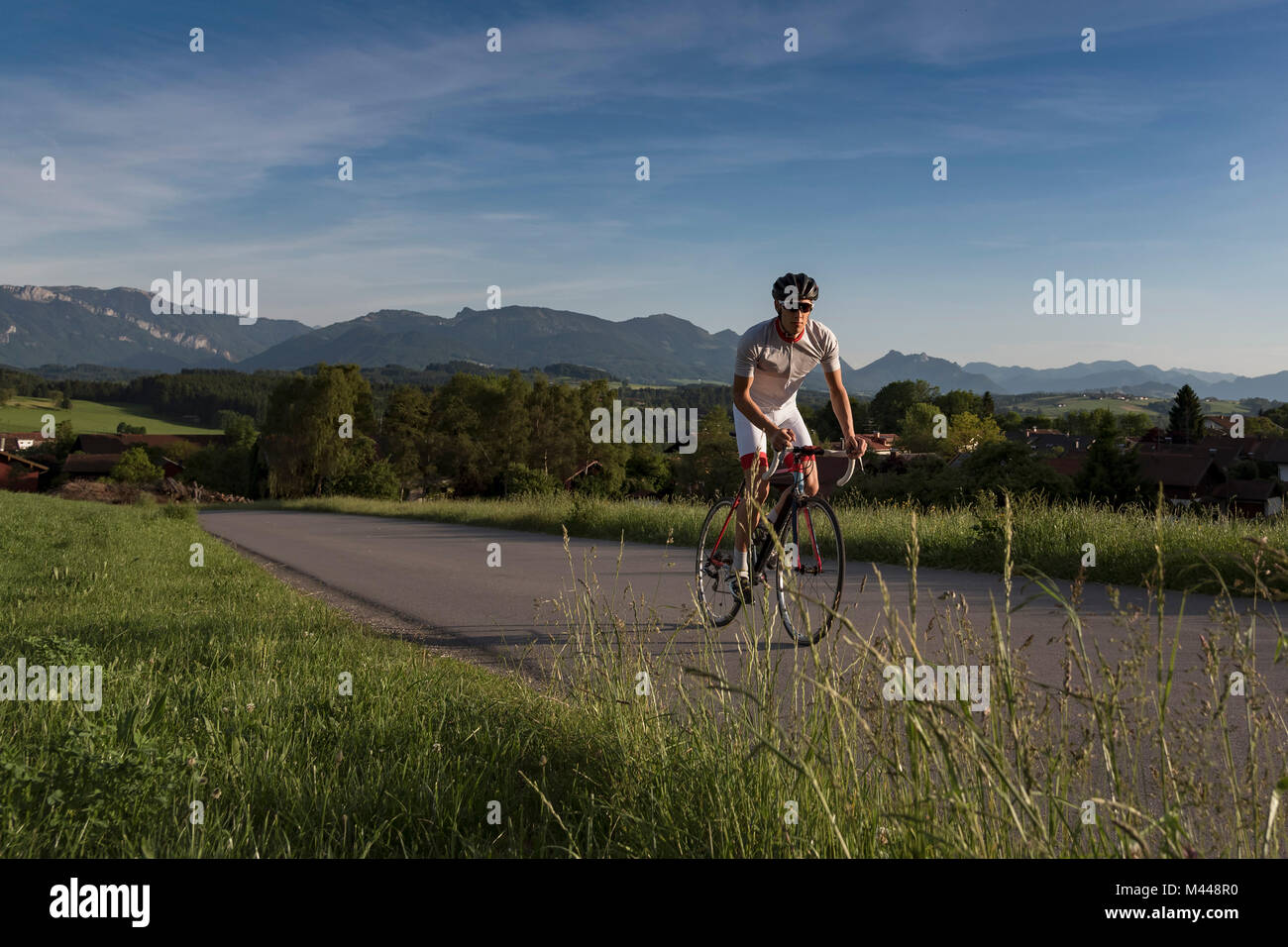 Giovane maschio ciclista ciclismo su strada rurale Foto Stock