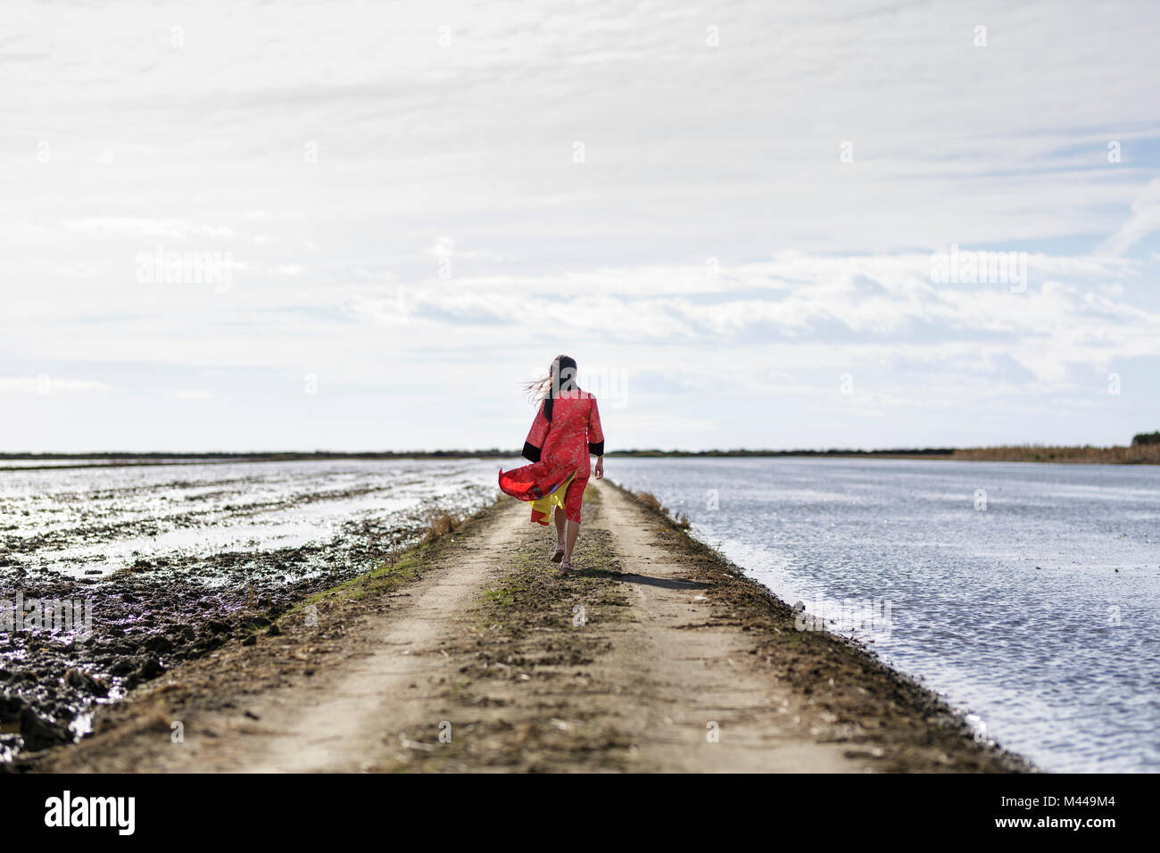 Vista posteriore del giovane donna asiatica su sterrato dal mare in abbigliamento tradizionale, Tarragona Catalogna Foto Stock