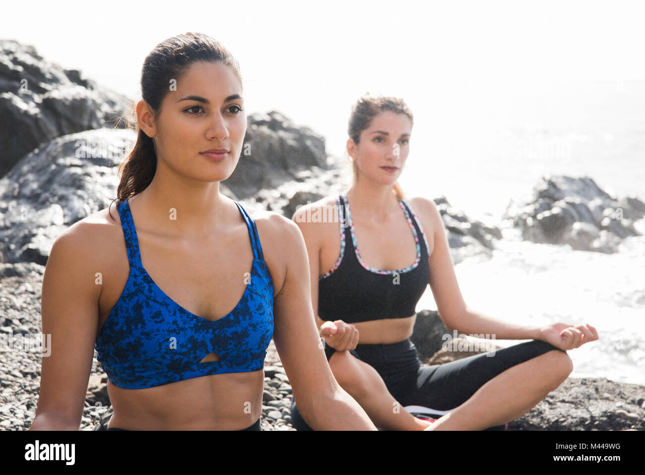 Due giovani donne a praticare yoga lotus pongono sulla spiaggia, Las Palmas, Isole Canarie, Spagna Foto Stock