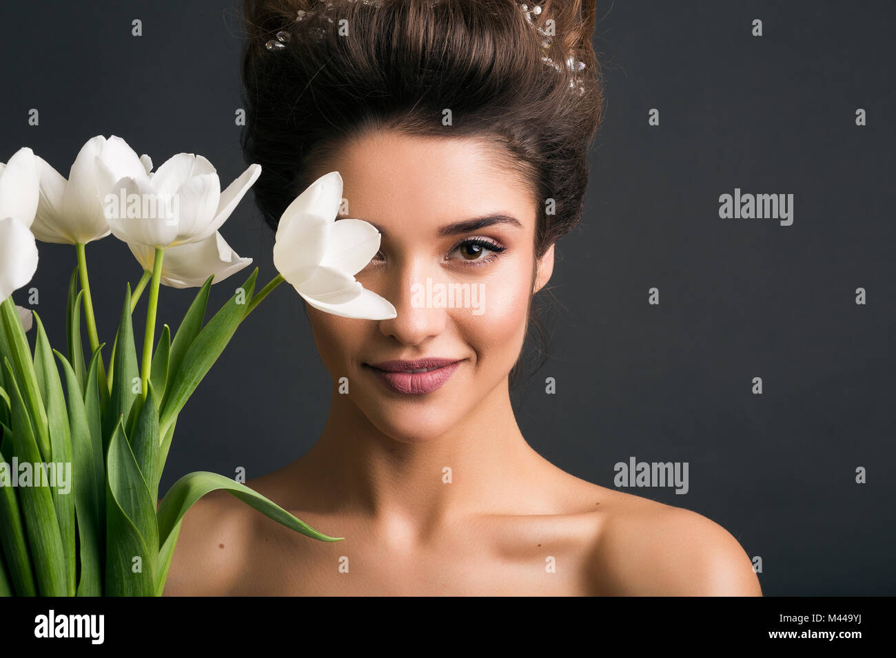 Donna che indossa tiara tenendo i tulipani Foto Stock