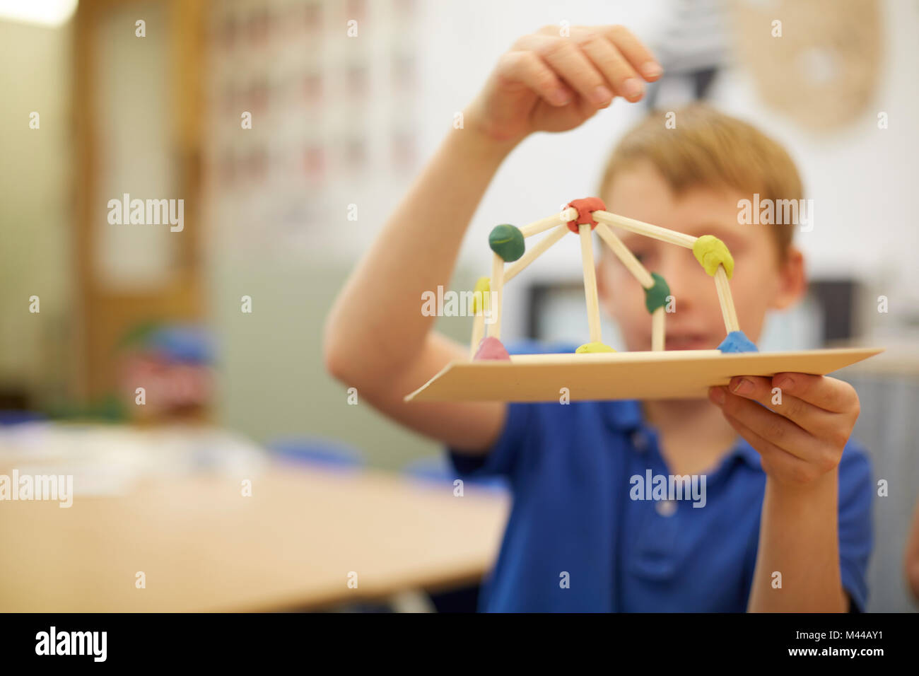 Scolaro rendendo la sfera e stick modello in aula presso la scuola primaria Foto Stock