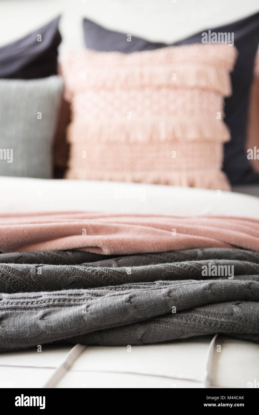 Close up dettaglio del grigio e rosa buttare i tappeti in verticale Foto Stock