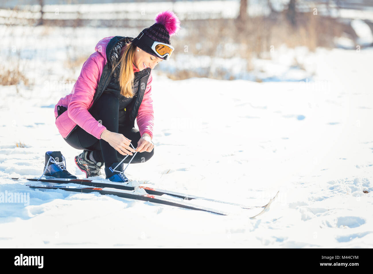 Donna cross country sciatore mettendo su sci Foto Stock