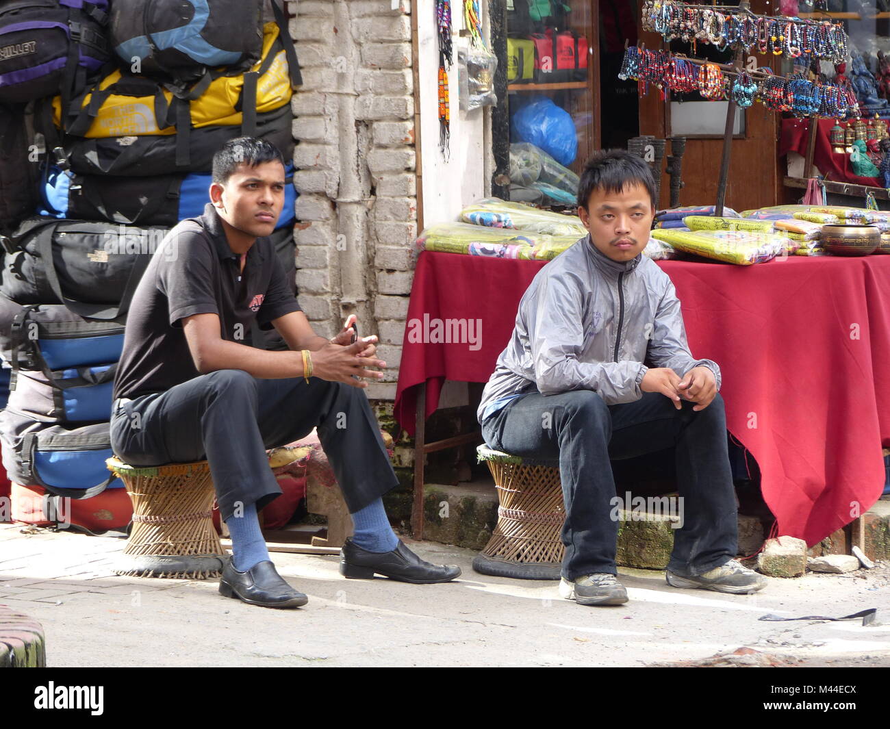 Kathmandu, Nepal, 4 settembre 2015: due nepalesi uomo seduto di fronte al loro negozio e attendere per i clienti Foto Stock