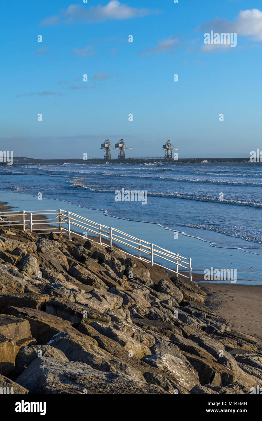Aberavon Beach guardando ad est verso le opere in acciaio e il dock gru, Galles del Sud Foto Stock