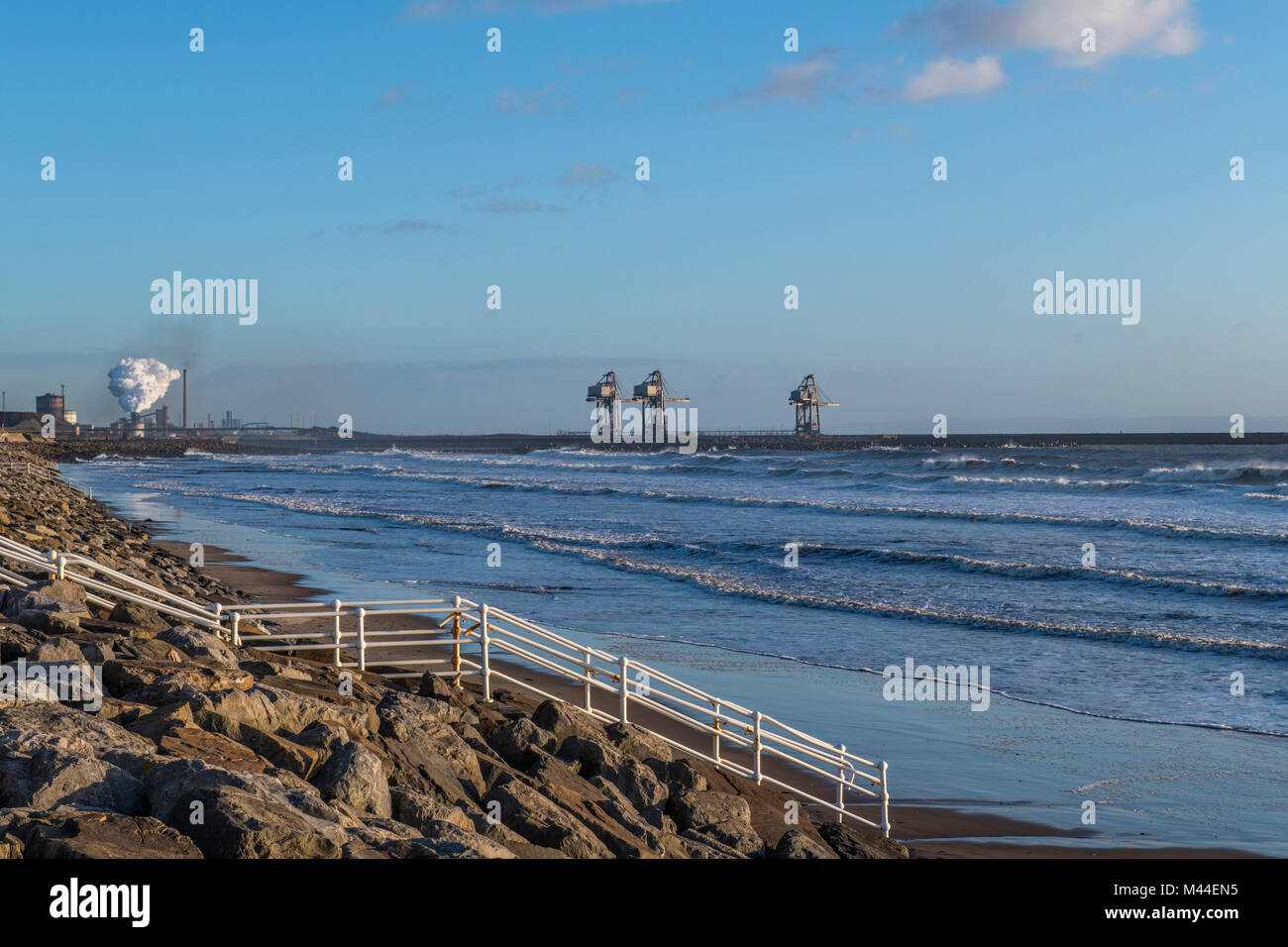 Aberavon Beach guardando ad est verso le opere in acciaio e il dock gru, Galles del Sud Foto Stock