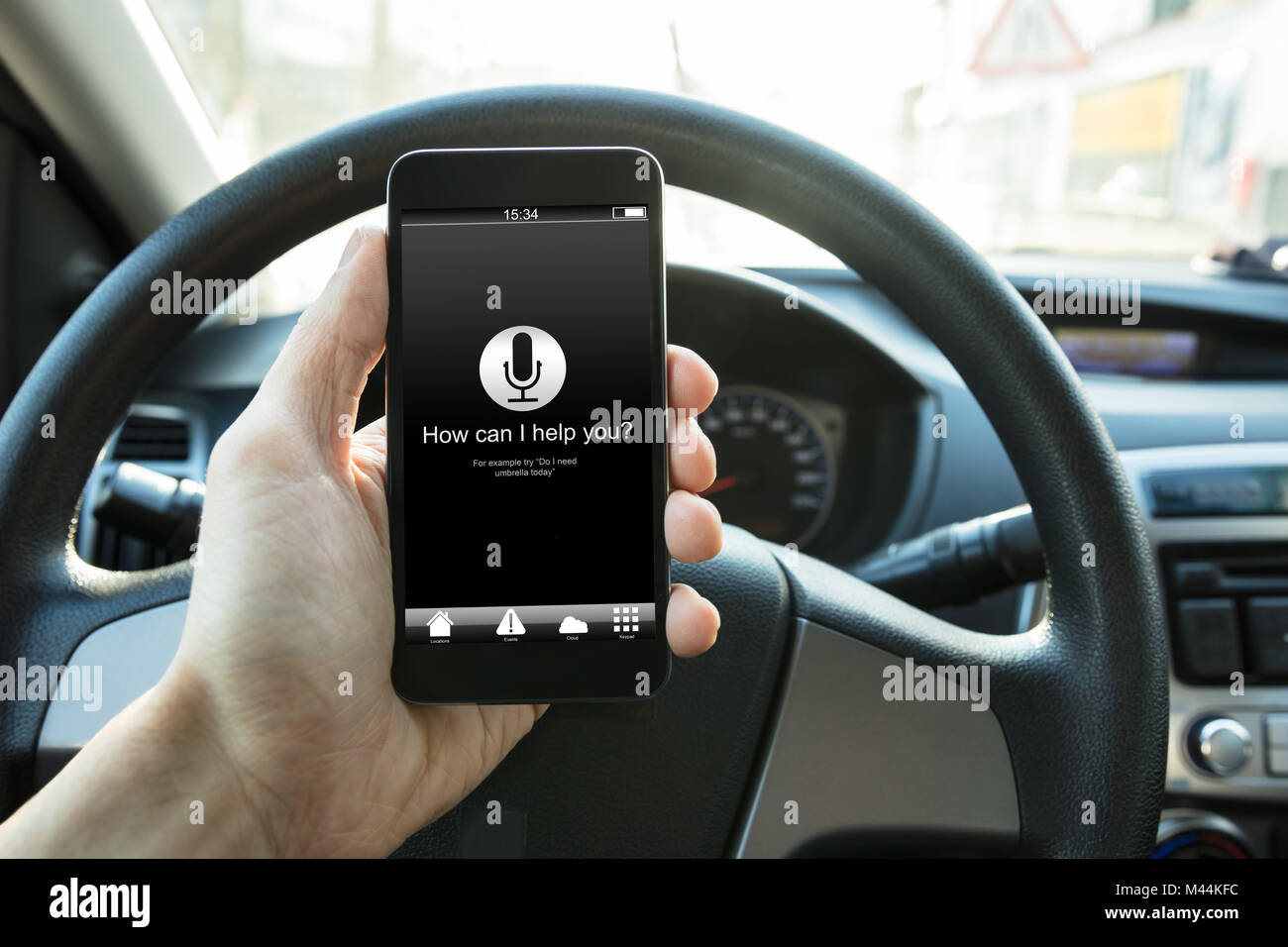 Mano azienda smart phone con come posso aiutarti? Il testo sullo schermo in auto Foto Stock