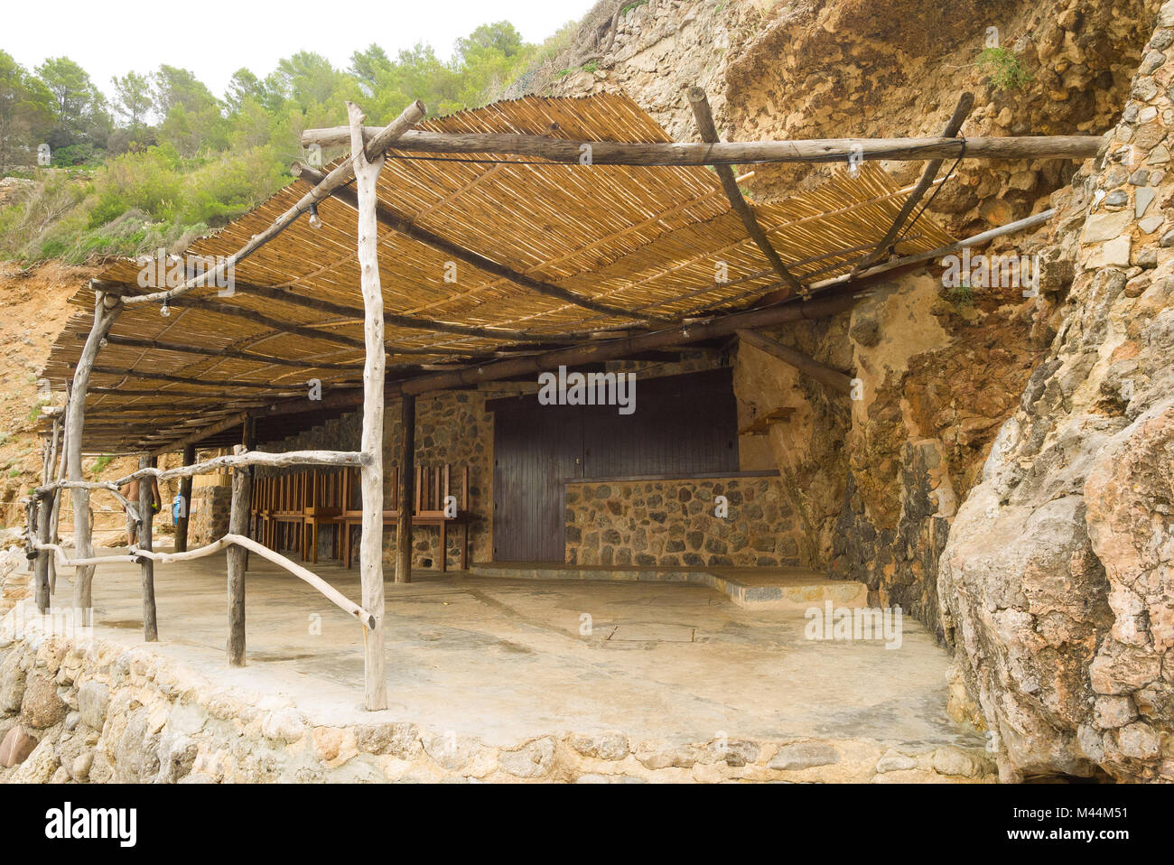 Una spiaggia rustico rifugio in Deia fornisce sollievo dal sole in una calda giornata estiva a Mallorca, Spagna. Foto Stock