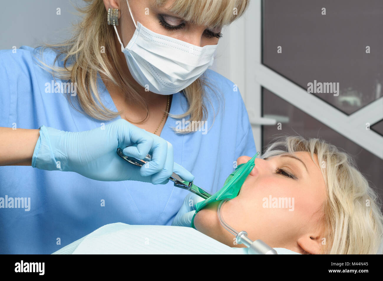 Dentista con paziente, installazione di diga in gomma Foto Stock
