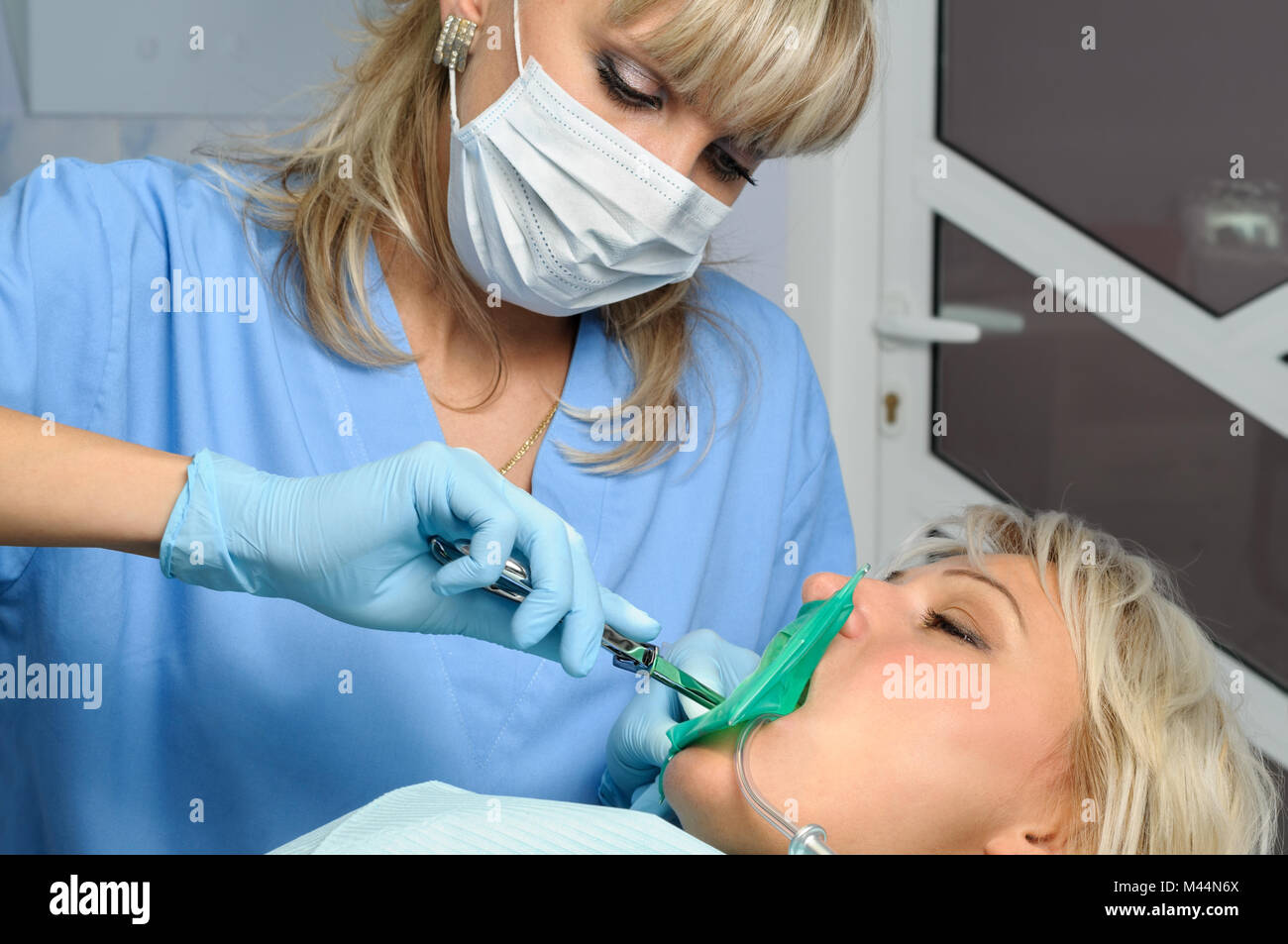 Dentista con paziente, installazione di diga in gomma Foto Stock