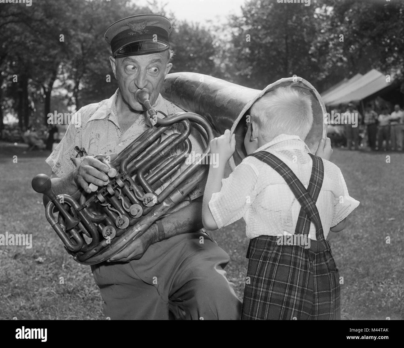 Ragazzo giovane ottiene un fiore infantile, sogno di musica durante una dimostrazione di strumenti musicali antichi, ca. 1956. Foto Stock