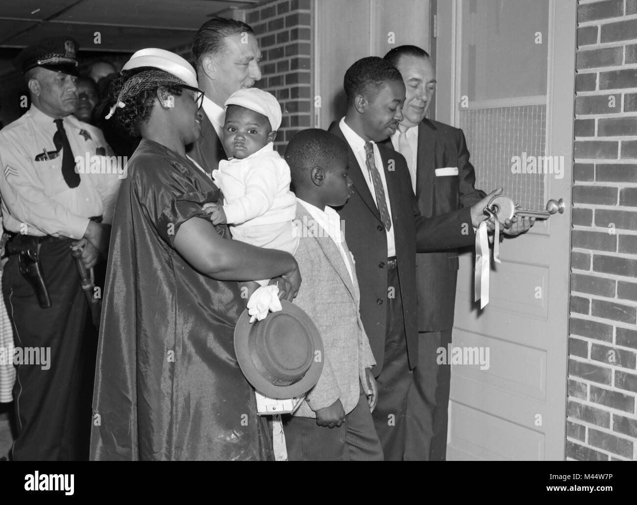 Il sindaco di Chicago Richard J. Daley, estrema destra, aiuta un nuovo inquilino e la sua famiglia con un cerimoniale di chiave per loro costruito di recente progetto di alloggiamento appartamento, ca. 1962. Foto Stock