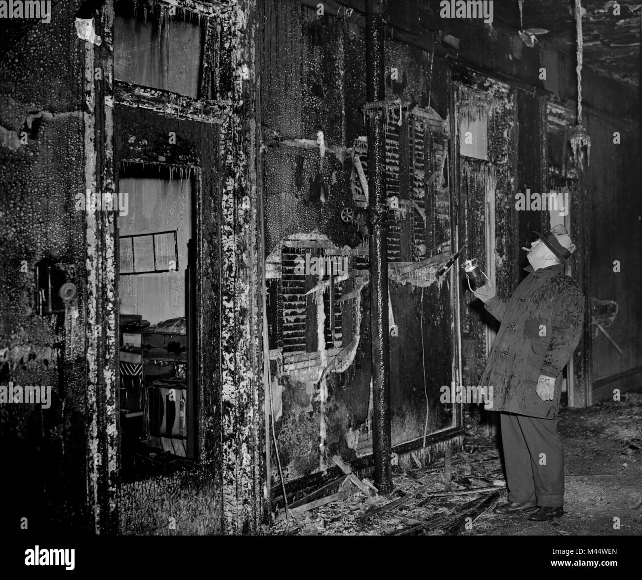 Un ispettore di arson esamina il pesce eviscerato interno del fuoco in scena a Chicago, ca. 1958. Foto Stock