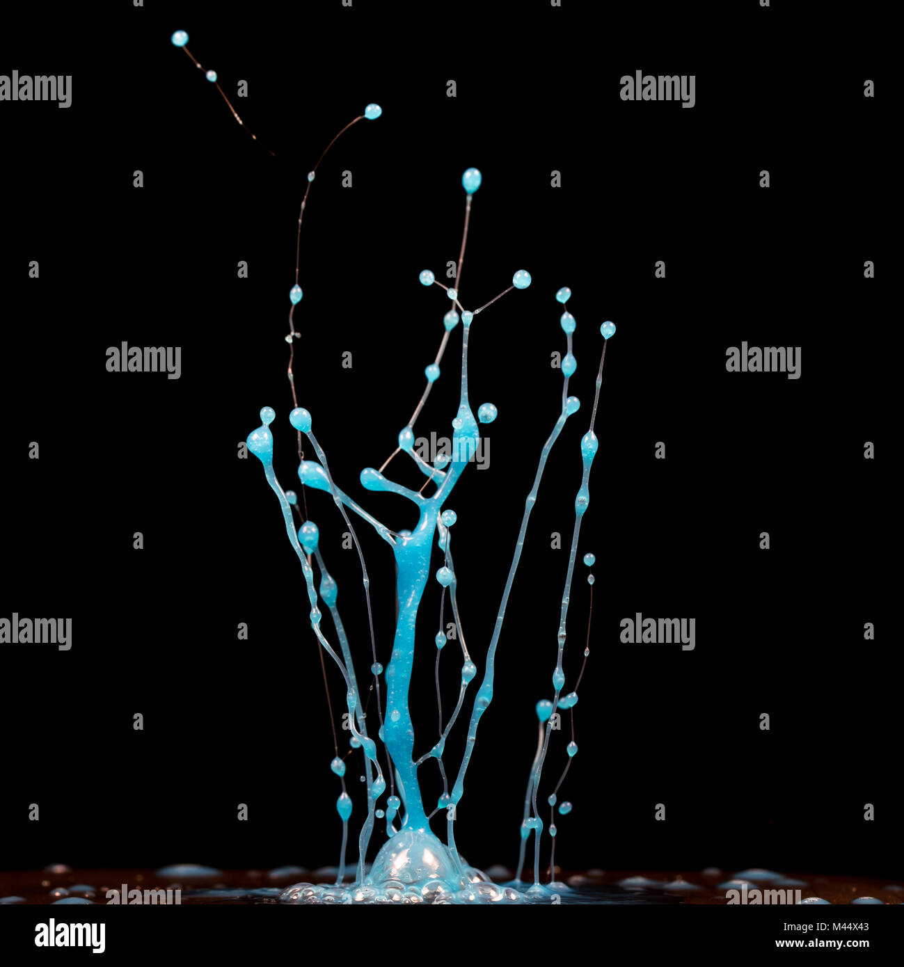 Esplosione di spruzzi e di burst di fluido di colore vernice o inchiostro su uno sfondo nero Foto Stock