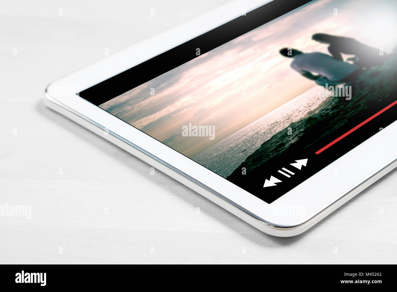 Film Online streaming con il dispositivo mobile. Chiudere fino a bianco tablet sul tavolo di legno con immaginario lettore video e film servizio di streaming. Foto Stock