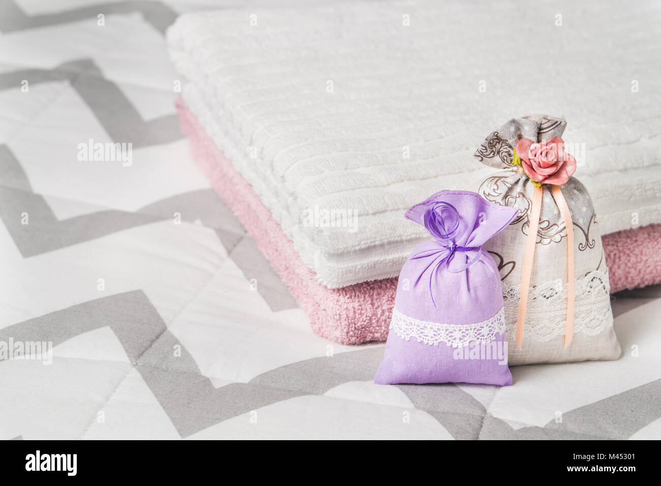 Due sacchetti profumati appoggiato su due asciugamani sul letto. Profumata lavanda sacchetti per la casa di interior design e di storage. Sacchetti decorativi con odore di Nizza. Foto Stock