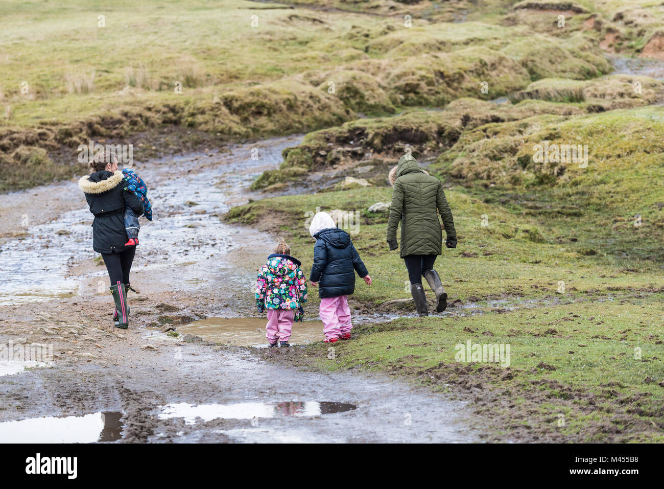 Le madri e i loro figli a camminare su una pista melmosa a Ruvida Tor su Bodmin Moor in Cornovaglia. Foto Stock