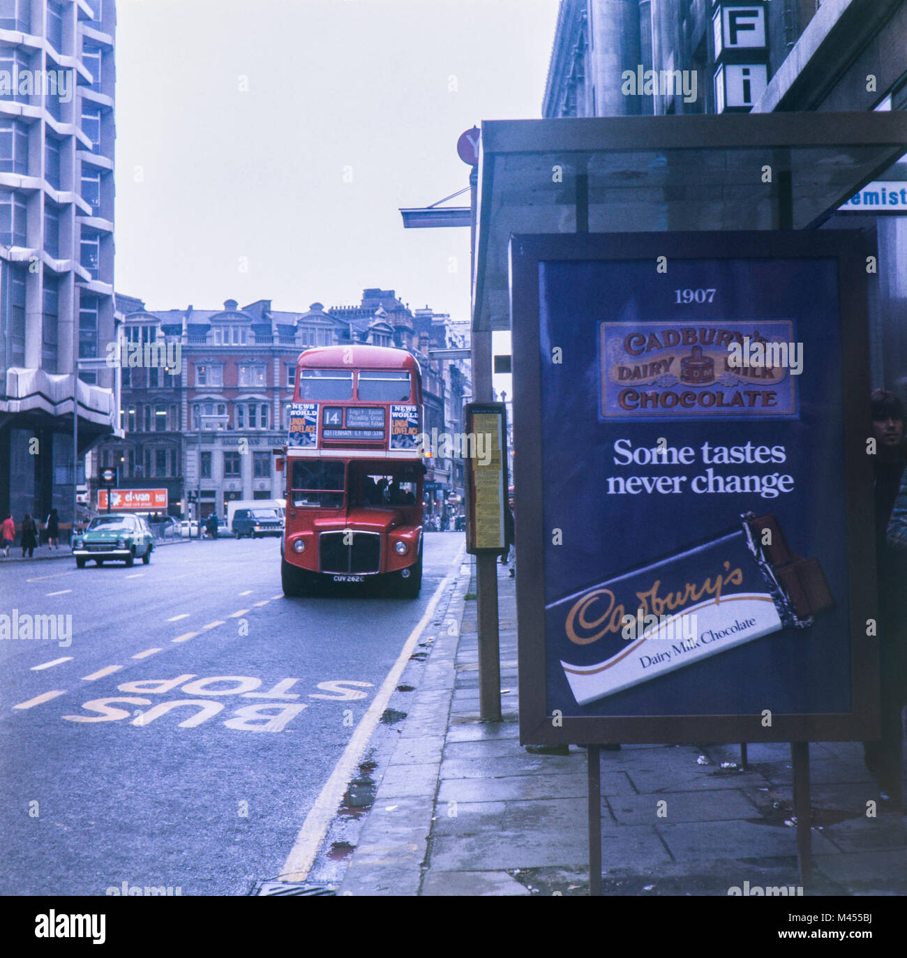 L'AEC Routemaster London Bus numero 14 sul percorso per la stazione di Tottenham Court Road lungo con un vecchio Cadbury al cioccolato di annuncio. Circa settanta Foto Stock