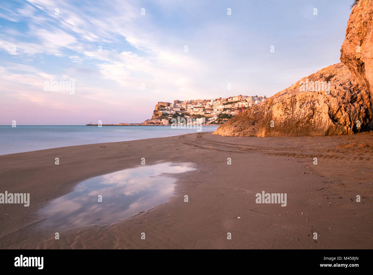 Vista del villaggio di Peschici dalla spiaggia al tramonto, Foggia district, Puglia, Italia Foto Stock