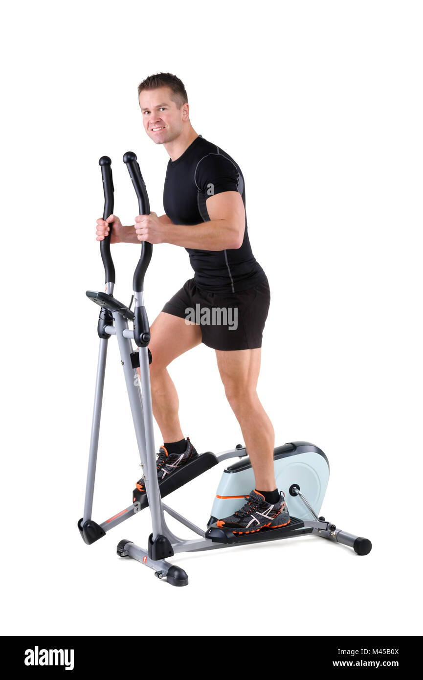 Giovane uomo facendo esercizi sul trainer ellittico Foto Stock