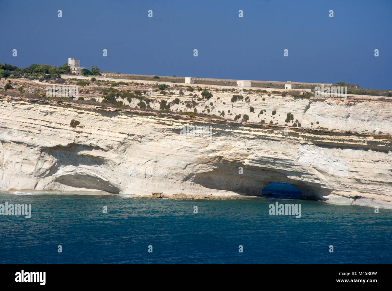 Bianche scogliere con gallerie e grotte sulla costa orientale di Malta. Foto Stock