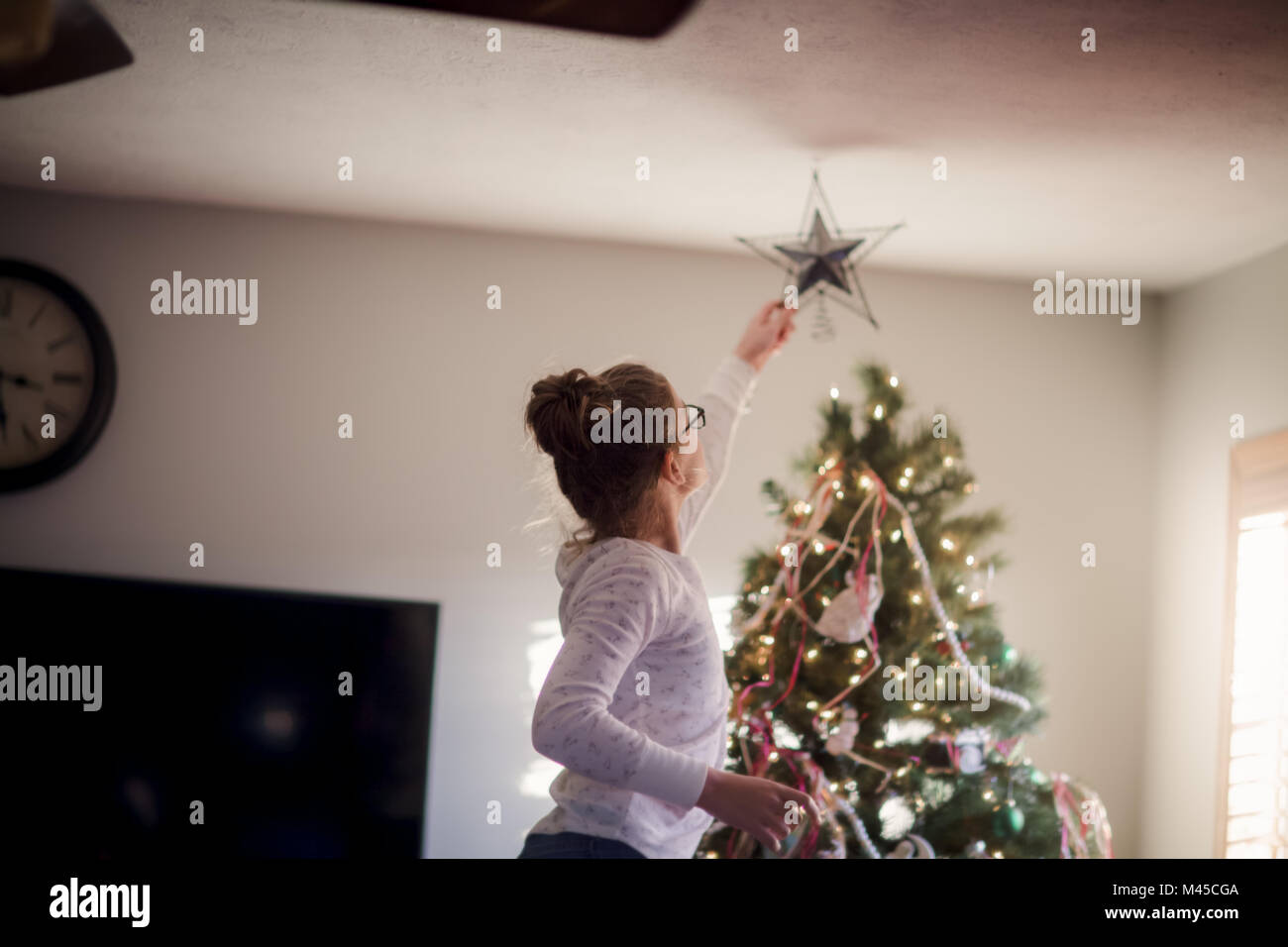 Ragazza mettendo le decorazioni di Natale Foto Stock