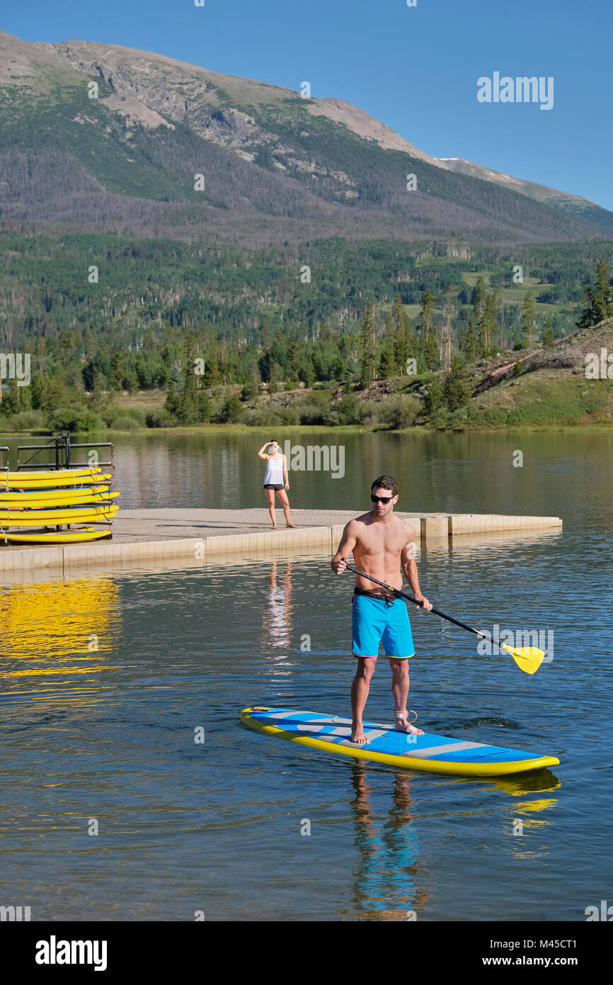 L'uomo stand up paddleboarding sul lago, Frisco, Colorado, STATI UNITI D'AMERICA Foto Stock