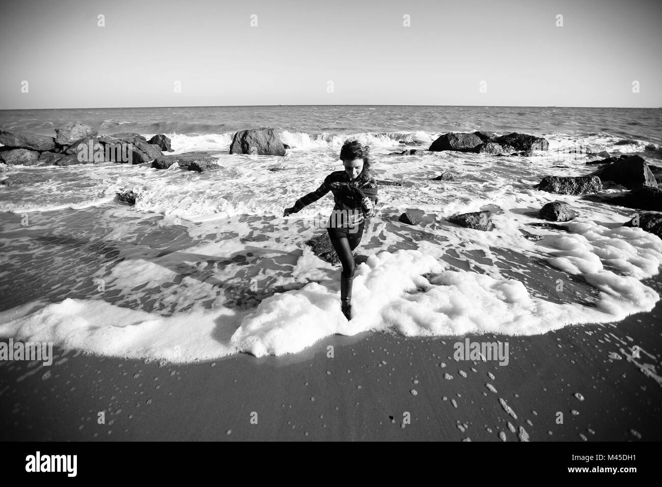 La donna in esecuzione dall'oceano onda sulla spiaggia, Oblast di Odessa, Ucraina Foto Stock