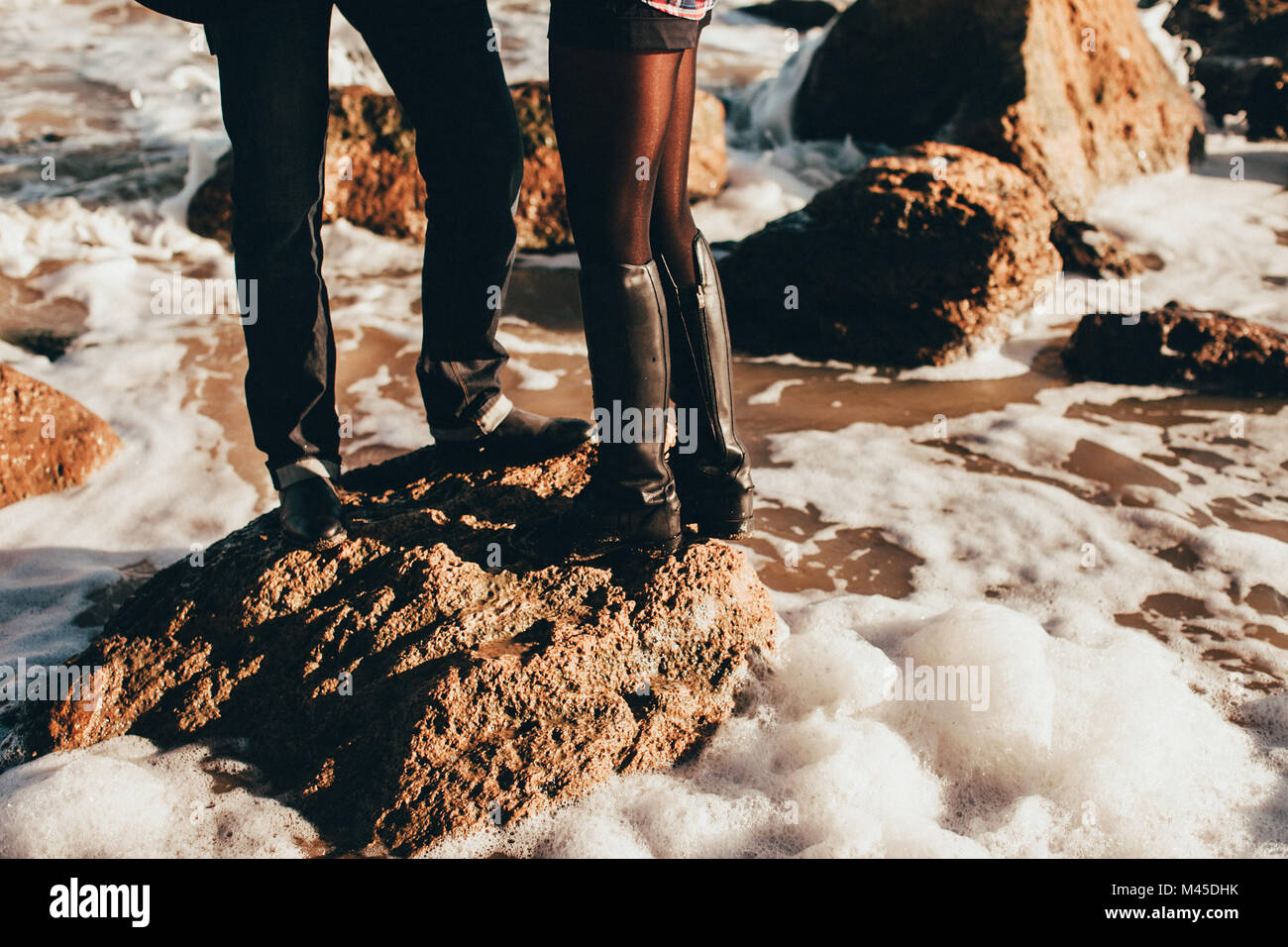 Metà adulto giovane in piedi sul mare rock, ritagliato, Oblast di Odessa, Ucraina Foto Stock