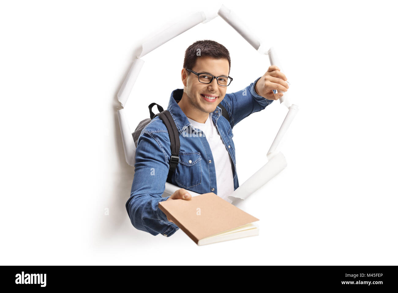 Studente dando un libro attraverso un foro della carta isolato su sfondo bianco Foto Stock