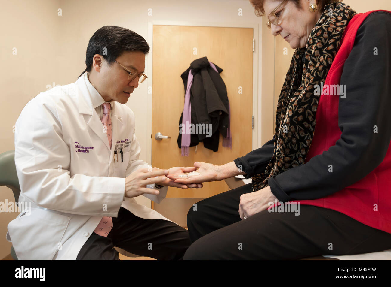 Chirurgo ortopedico esaminando una mano del paziente dopo Dupuytren contrattura della chirurgia sul suo dito e Palm. Foto Stock