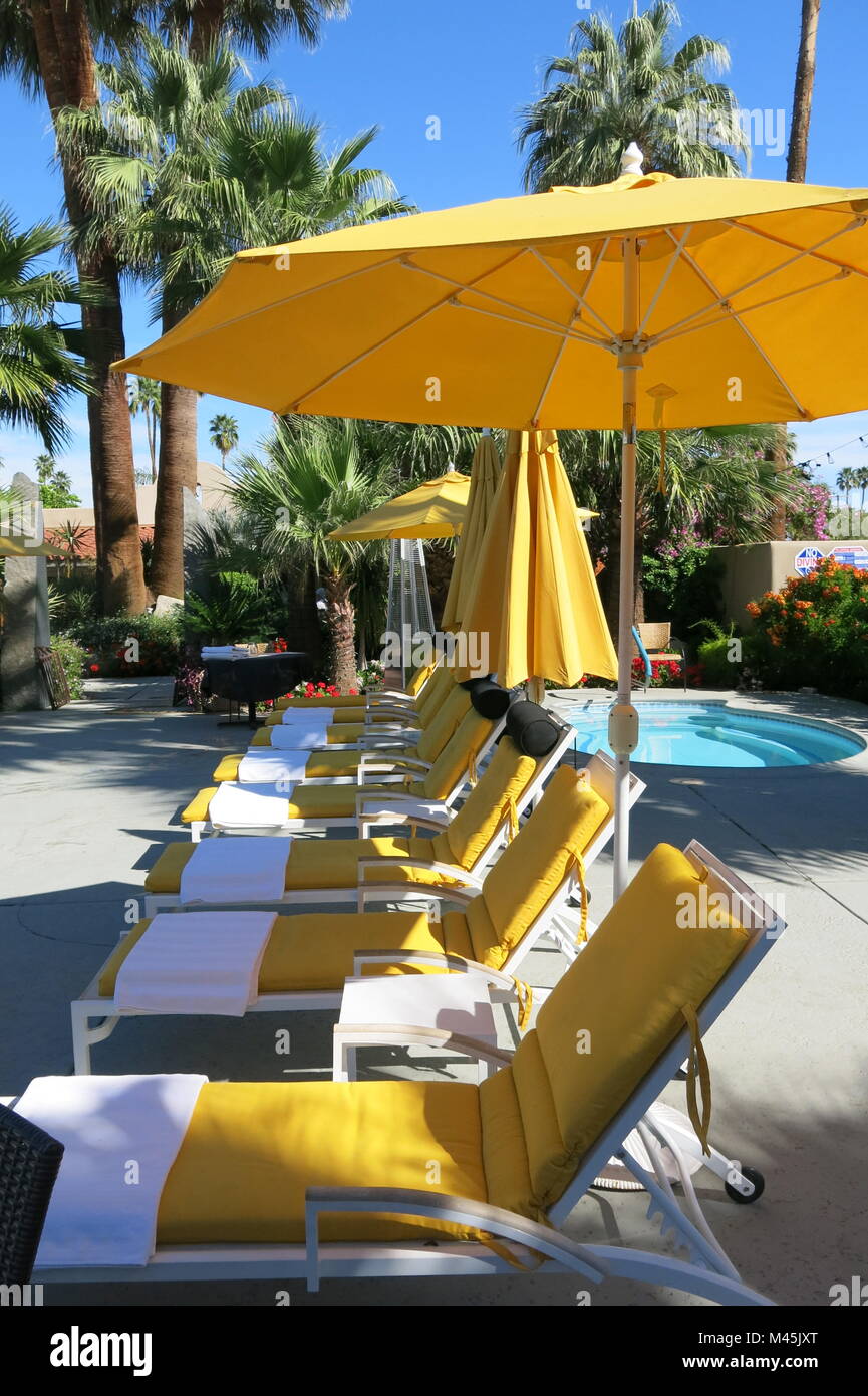 Il giallo di sedie a sdraio e ombrelloni in piscina a Palm Springs, California; Colt's Lodge Bed & Breakfast Foto Stock